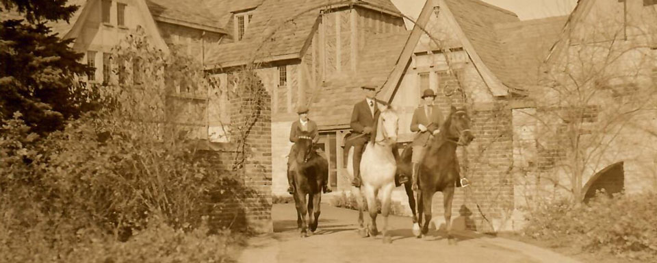 Hazle Buck Ewing, Julia Hodges, and Alfred Klotts sit atop their horses at the gate of the manor.