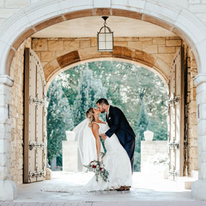 Bride and groom kiss in front of the gate.